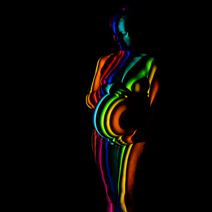 Projectiefoto van zwangerenvrouw diverse neonkleuren